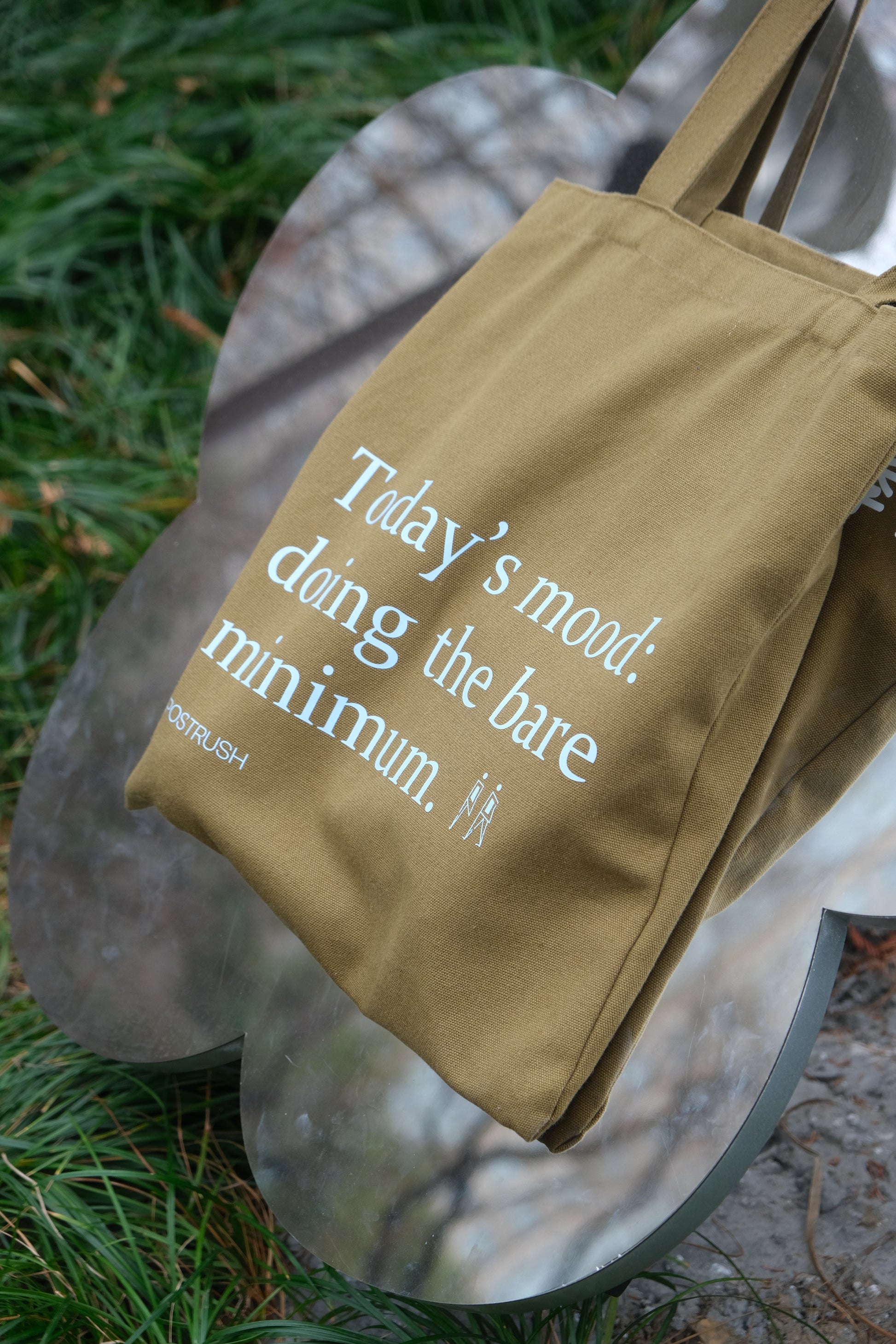 Brown tote bag with humorous text in a creative lifestyle mirror shot.