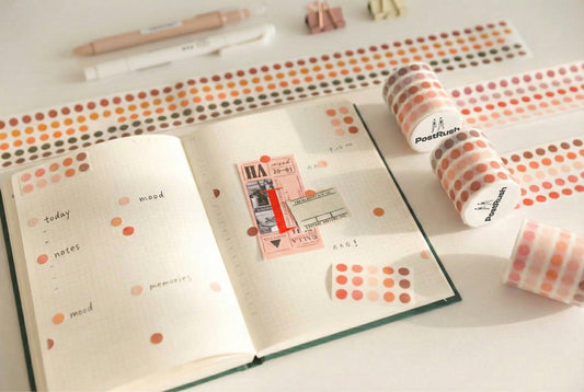 An open journal decorated with color-coding dot stickers, used for mood tracking and daily notes.