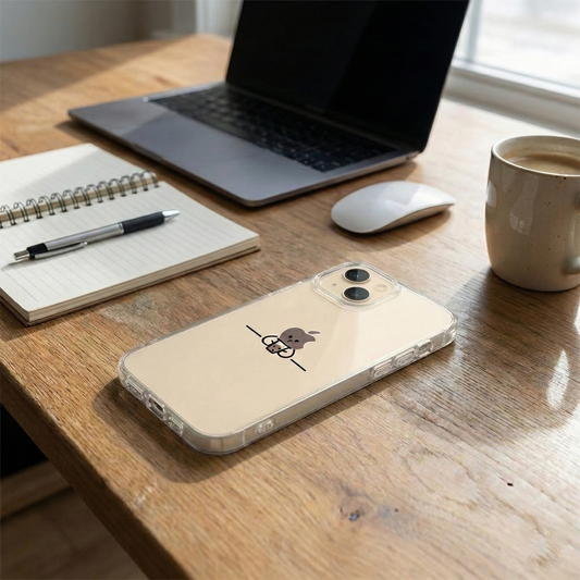 A minimalist desk setup featuring a clear phone case resting on a wooden table beside a laptop, notebook, pen, wireless mouse, and a cup of coffee.